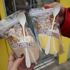 two plastic bags filled with food and spoons in front of a storefront window