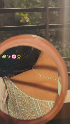 a woman looking through a magnifying glass with flowers on the side and behind her