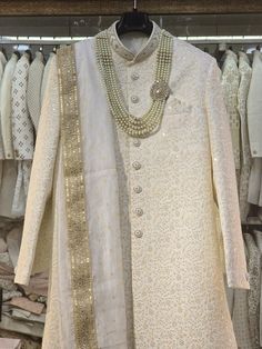 Make a grand statement on your special day with a luxurious Sherwani crafted from premium fabrics (like silk, brocade, or georgette) for ultimate comfort and sophistication. Our collection boasts a variety of designs to suit every taste: Classic elegance: Opt for a timeless Sherwani with intricate embroidery on the collar or cuffs. Modern flair: Go for a Sherwani with a unique neckline or a trendy color palette. Regal opulence: Choose a Sherwani with rich embellishments like zardozi work for a t Formal White Raw Silk Traditional Wear, Ceremonial White Raw Silk Kurta, White Sherwani With Cutdana For Formal Occasions, Formal White Sherwani With Cutdana, Off White Sherwani With Dabka For Reception, Off White Dabka Sherwani For Reception, White Dupatta With Dabka For Reception, White Dabka Dupatta For Reception, Reception Off-white Sherwani With Dabka