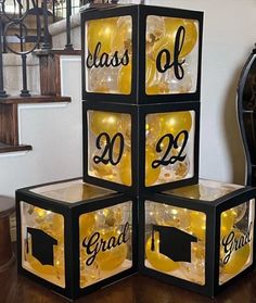 four cubes with graduation decorations on them sitting in front of a stair case that says class of 2012