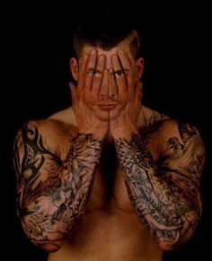 a man with tattoos covering his face and hands