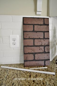 a brick wall in the corner of a kitchen next to two white electrical outlet covers