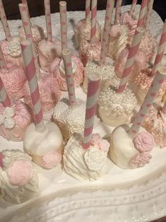 a white cake with pink and grey striped candles on it's side, surrounded by heart shaped candies