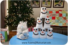 a blue table topped with snowmen next to a christmas tree