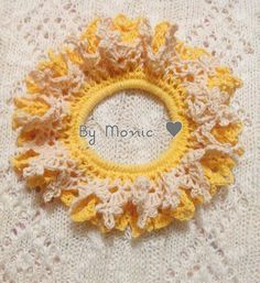 a crocheted yellow and white doily with the word by momic written on it