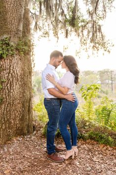 a man and woman embracing under a tree