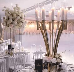 a table set up for a wedding with candles and flowers