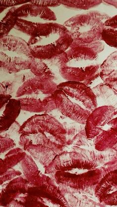 red lipstick imprints on the surface of a tablecloth with white paper over it