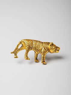 a gold colored bear figurine on a white background