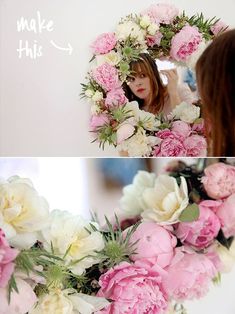 a woman is looking at her reflection in the mirror and holding flowers up to her face