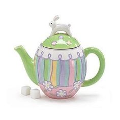 a green teapot filled with marshmallows on top of a white surface