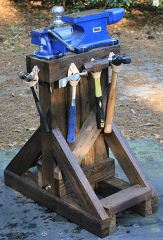 an old wooden tool stand with tools on it's legs and hammers in the back