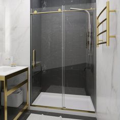 a bathroom with a glass shower door and marble counter tops, along with a gold towel rack