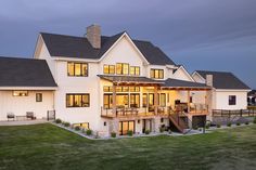 a large white house sitting on top of a lush green field