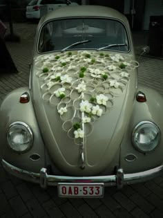 an old car with flowers on the hood