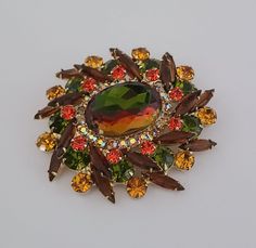 Extraordinary vintage Juliana D&E brooch in luscious fall colors. The large brooch is centered with a massive heliotrope faceted glass stone that has a complex color and changes it depending on the light. It's surrounded with AB rhinestones and stacked layers of light and brown navettes alternating with green, yellow and red crystals. The plating is in excellent condition Vintage Juliana D&E Large Brooch is a Book Piece and is featured on the COVER of "The Art Of Juliana Jewelry" by Katerina Mus Juliana Jewelry, Jewelry Holders, West New York, Book Pieces, Diamond Paintings, Red Crystals, Faceted Glass, Vintage Costume Jewelry, Vintage Costumes