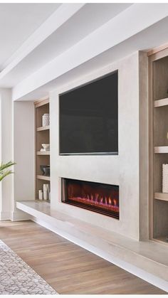 a living room filled with furniture and a flat screen tv mounted on a wall above a fire place