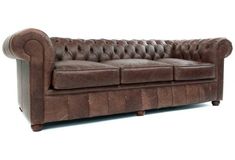 a brown leather couch sitting on top of a white floor