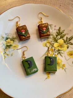 four pieces of food are sitting on a plate with gold earwires and earrings