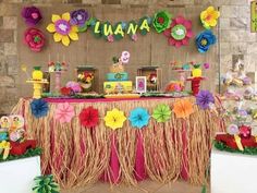 the table is decorated with colorful flowers and tiki decorations for luauana party