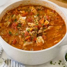 a white bowl filled with meat and vegetable soup