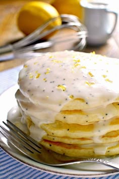 a stack of pancakes covered in white frosting and lemon zest on a plate