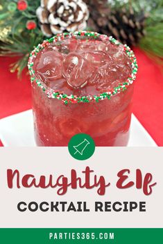 a close up of a drink in a glass on a plate with christmas decorations and pine cones