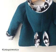 a green sweater with black and white designs on it