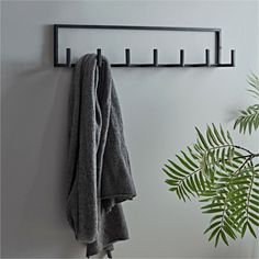 a towel rack is hanging on the wall next to a potted plant