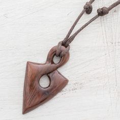 In the shape of a spearhead the pendant of this necklace is hand-carved from a piece of natural estoraque wood that displays a beautiful dark brown hue. Costa Rican artisan Milagro Cascante creates this striking necklace which circles the neck with an adjustable length of cotton cord. Adjustable Carved Brown Necklace, Brown Carved Amulet Necklaces, Brown Carved Pendant Necklace, Bohemian Brown Arrowhead Necklace, Brown Arrowhead Necklace For Gift, Wood Sculpture Art, Fantasy Craft, Wood Jewelery, Vehicle Reference