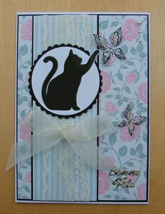 a close up of a card with a cat on it and butterflies in the background