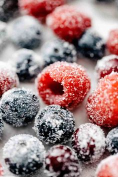 frozen berries and raspberries on a white surface