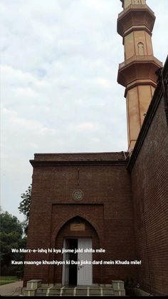 an old brick building with a clock tower on the top and stairs leading up to it