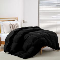 a black comforter on a bed in a bedroom