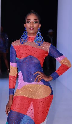 a model walks down the runway in a colorful dress