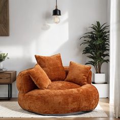 a living room with an orange chair and potted plant