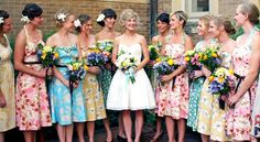 a group of women standing next to each other with bouquets in their hands and flowers in their hair