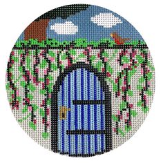 a cross stitch picture of a blue door with pink flowers on the outside and green trees in the background