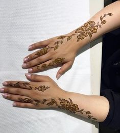 two hands with henna tattoos on them