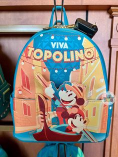 a blue backpack with an image of mickey and minnie on it hanging from a hook