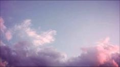 an airplane flying in the sky with pink clouds