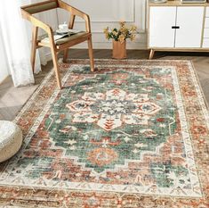 a large rug with an ornate design on the floor in front of a chair and sideboard