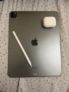 an apple ipad with a pen on top of it