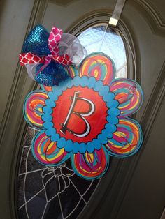 a colorful door hanger with the letter b on it's front porch window