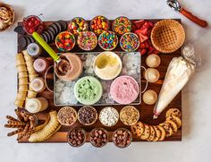 a wooden platter filled with lots of different foods and desserts on top of it