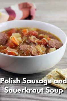 polish sausage and sauerkraut soup in a white bowl with crackers on the side