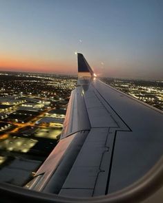 the wing of an airplane flying over a city at night