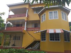 a yellow building with red and white balconies