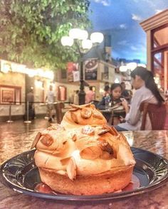 a plate with some food on it and people sitting at tables in the back ground