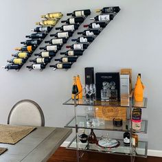 a glass table with bottles of wine on it next to a wall mounted wine rack